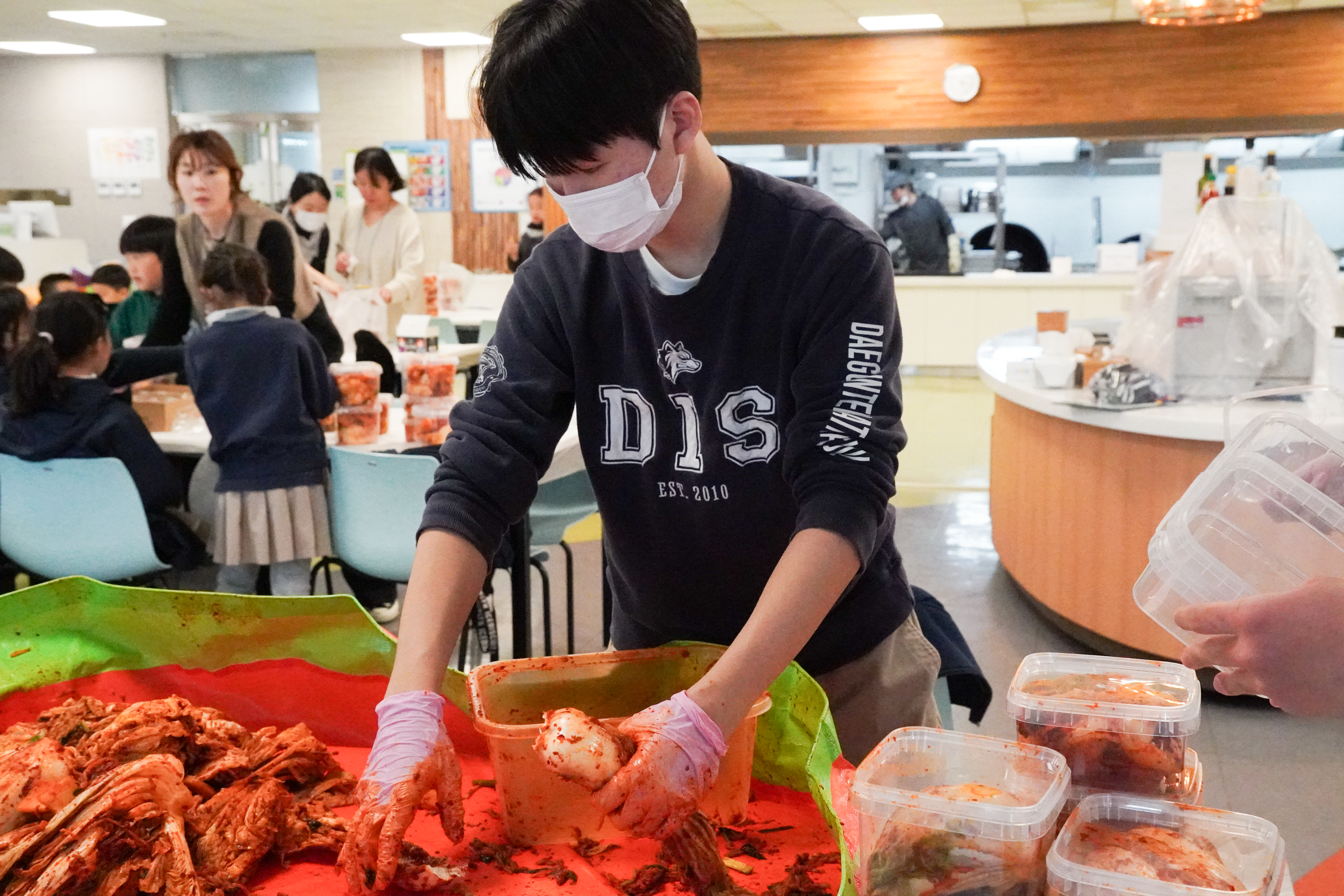 Students preparing kimchi together at a Key Club community service event