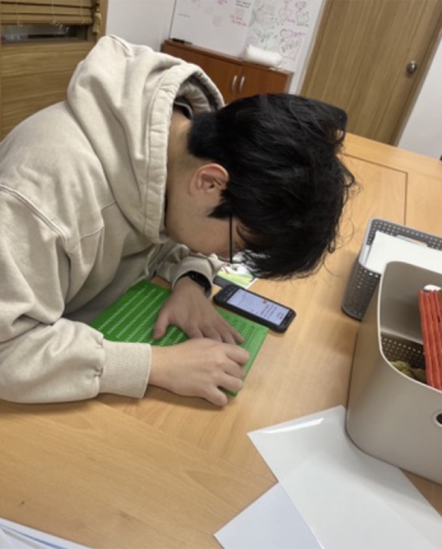 A student translating and transcribing a book into Braille